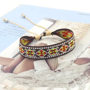 Close-up of bohemian woven bracelet with red and yellow geometric diamond embroidery