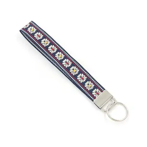 Ethnic style embroidered wristlet keychain with white daisy pattern on navy blue webbing