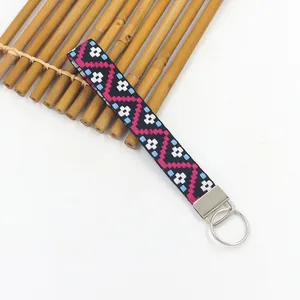 Primer plano detallado de la pulsera étnica con diseño jacquard y llavero metálico