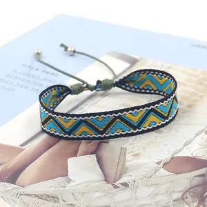 Detail of bohemian geometric woven bracelet with adjustable cord and silver beads