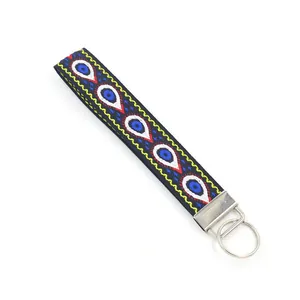 Détail d'un porte-clés brodé ethnique avec motif œil de protection et anneau métallique argenté