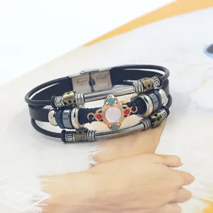 Detail of bohemian multilayer leather bracelet with gemstone cross and magnetic clasp