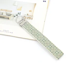 Ethnic embroidered keychain wristlet with light green floral pattern and metal clasp
