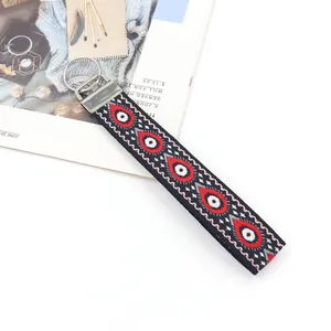 Détail d'un porte-clés jacquard bohème avec motif géométrique d'oeil maléfique rouge