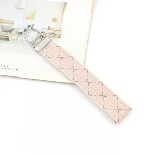 Ethnic embroidered keychain wristlet with pink and beige geometric floral pattern