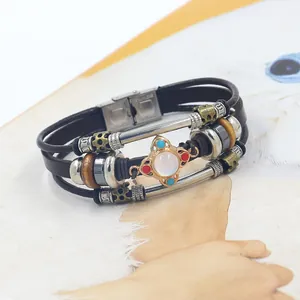 Detail of multi-layer leather bracelet with white gemstone and stainless steel clasp