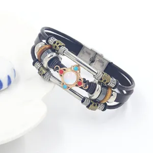 Macro detail of multi-layer leather bracelet with bronze ring and blue enamel accents