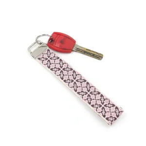 Detailed view of bohemian floral embroidered wristlet strap with metallic clasp and key