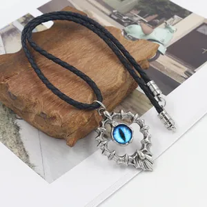 Gros plan du pendentif cœur à épines avec œil bleu et cordon en cuir tressé noir