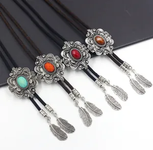 Detail van vintage bolo-dassen met ovale edelstenen, zilveren beslag en veren hangers