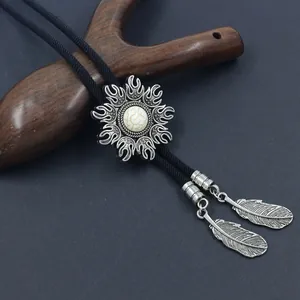 Detailed close-up of bolo tie with silver flower pendant and white turquoise stone