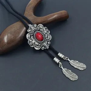 Details von Vintage-Bolo-Tie mit Blumenrelief und rotem Edelstein auf geflochtener Kordel