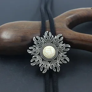 Close-up of antique silver bolo tie pendant with white turquoise stone on black cord