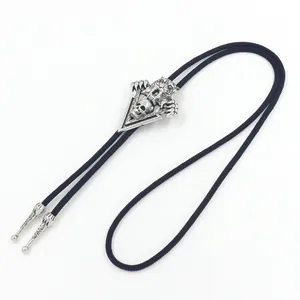 Vintage silver skull and tiger bolo tie with black braided cord and engraved metal tips