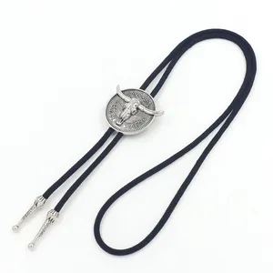Detail of silver alloy longhorn bolo tie with vintage floral patterns and black braided cord