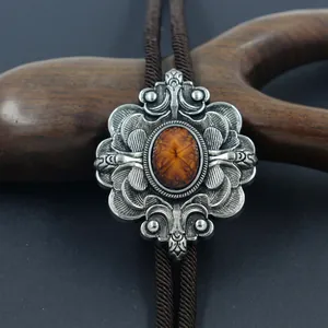 Nahaufnahme der Vintage-Bolo-Krawatte mit floralem Relief und bernsteinfarbenem Stein
