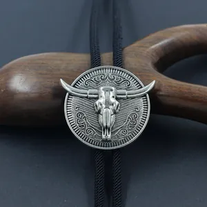 Vintage western bolo tie with antique silver bull head pendant on black woven cord