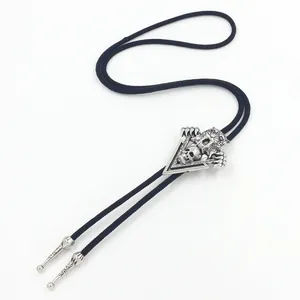 Vintage western bolo tie featuring silver skull and beast claw pendant on black woven cord