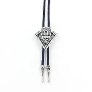 Close-up of vintage silver tiger and skull bolo tie with black braided cord and metal tips