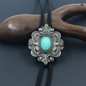 Detail van de vintage bolo tie met zilveren gravering en turquoise edelsteen