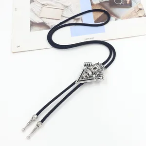 Close-up of a western bolo tie with a silver skull slide and black braided cord