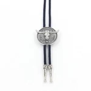 Detail of silver bull head bolo tie slider with floral engraving and braided cord