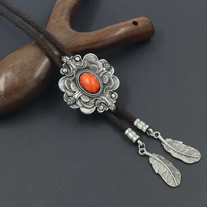 Detail van vintage bolo tie met rode edelsteen en zilveren veerhangers in detail