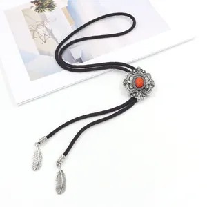 Macro-detail van vintage bolo tie met oranje edelsteen en zilveren veerhangers