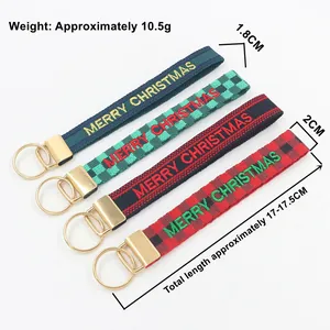Détail de quatre porte-clés brodés de Noël avec des anneaux en métal doré