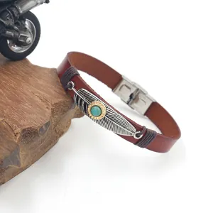 Detailed macro view of vintage leather bracelet with turquoise eagle feather charm