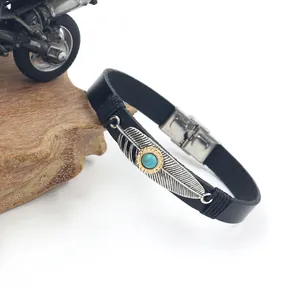 Bohemian black leather bracelet with silver feather and turquoise on a wooden stand