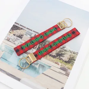 Détail du cordon de Noël à carreaux rouges et noirs avec texte Merry Christmas brodé en vert