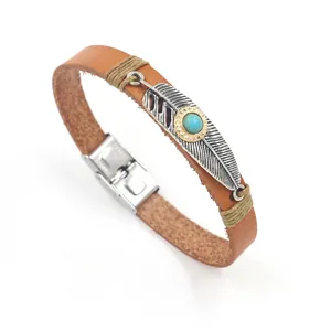 Detailed close-up of brown leather bracelet with silver feather and turquoise stone