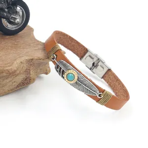 Detail of bohemian leather bracelet with silver feather charm and turquoise stone inlay