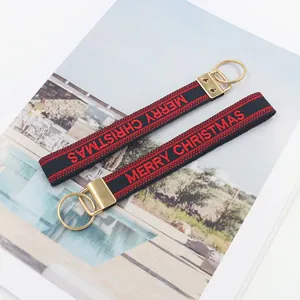 Détail du bracelet brodé Merry Christmas rouge et noir avec boucle en métal doré élégante