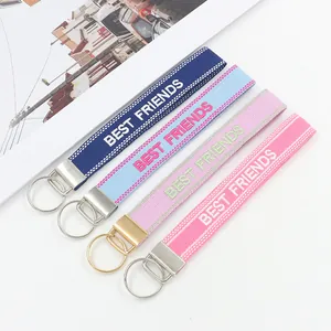 Detail of colorful jacquard webbing keychains with BEST FRIENDS embroidery and metal clips