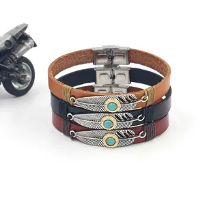 Macro detail of leather bracelet set featuring silver feather and turquoise stones