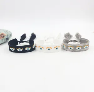 Detail of embroidered bohemian evil eye bracelets with tassel accents and colorful fabric