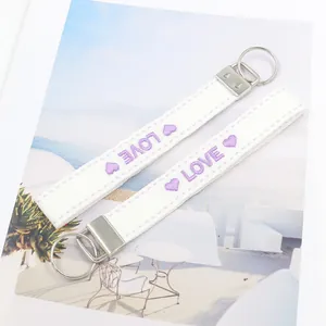 Llavero étnico de lona blanca con bordado LOVE púrpura y anilla de metal plateado