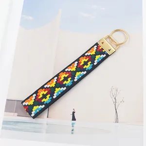 Détail d'un porte-clés brodé de style ethnique avec anneau en métal doré brillant