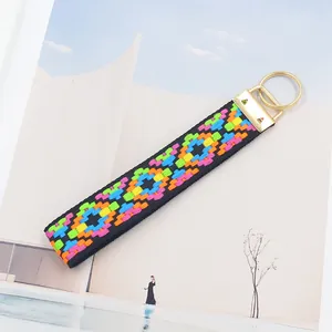 Détail de la broderie géométrique ethnique sur cordon noir avec fermoir en métal doré