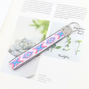 Dettaglio del cinturino jacquard geometrico colorato con clip in argento su sfondo naturale