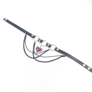 Detail of punk leather choker with red heart pendant, skull charms and metal chains