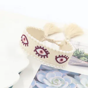 Bohemian woven cotton bracelet with evil eye embroidery and pearl bead trim with tassels