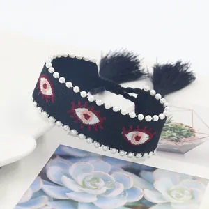 Bohemian black woven bracelet with faux pearls, evil eye embroidery and tassels