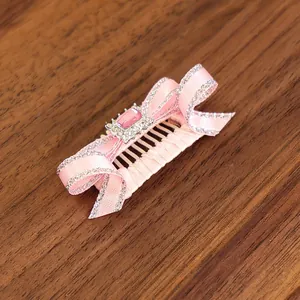 Vue détaillée d'un peigne à cheveux rose pour petits chiens avec gemme rose et paillettes argentées