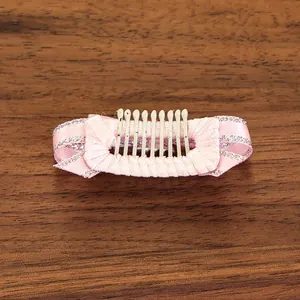 Détail d'un peigne à cheveux en ruban de satin rose avec bords scintillants pour petits chiens