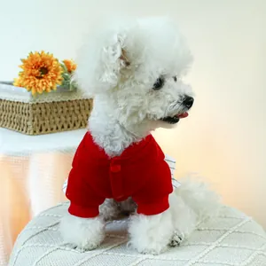 Dettaglio del maglione rosso per animali con polsini a costine e bottoni su cane bichon