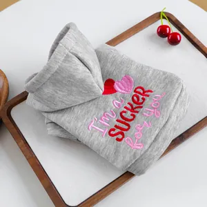 Détail d'un sweat à capuche gris pour chien avec broderie cœur et texte imprimé