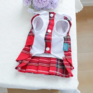 Détail de la robe pour animaux à carreaux rouges sur une nappe en dentelle blanche